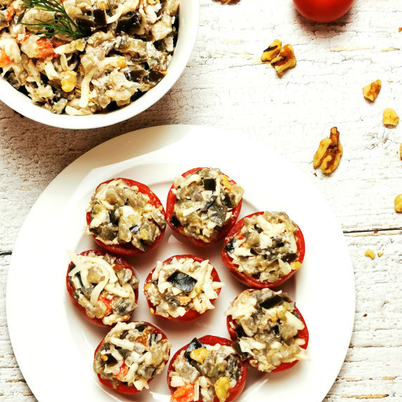 Eggplant salad stuffed tomatoes on a white plate