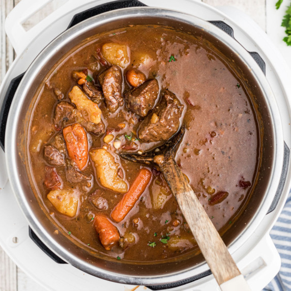 overhead view of an instant pot venison stew with a spoon digging in.