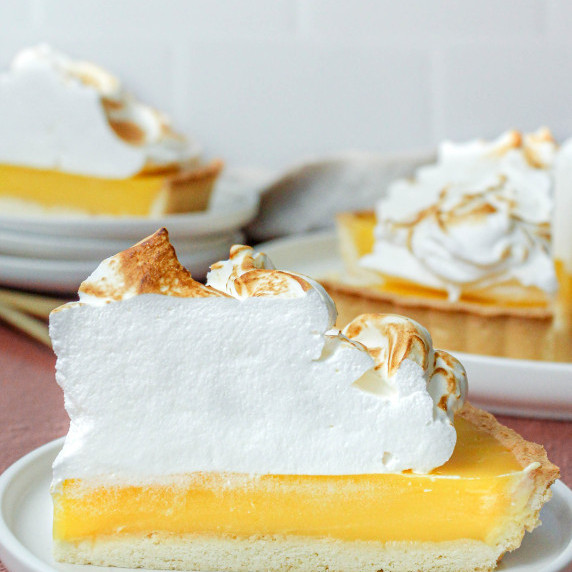 Italian meringue on a slice of lemon tart, with a white background