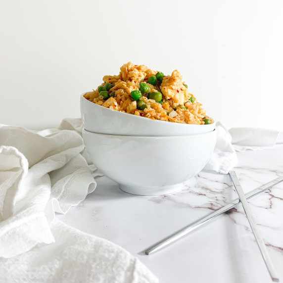 Bowl of kimchi cauliflower fried rice with chopsticks