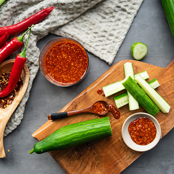 Korean BBQ Sauce on cutting board with cucumbers and red peppers