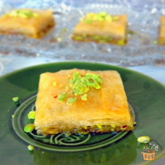 Lebanese Baklawa square with sugar syrup, Turkish filo pastry, and pistachios on a green plate