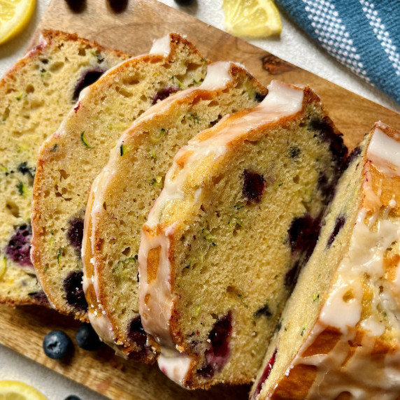 Slices of zucchini bread on a wooden cutting board.
