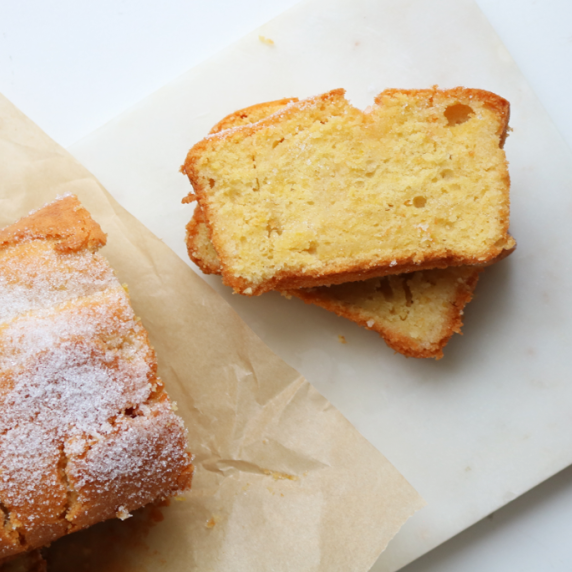 Slices of lemon drizzle cake arranged on a white background