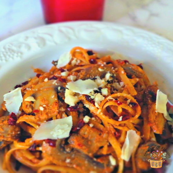 Linguine With Mushrooms with a macadamia nut-sundried tomato sauce topped with veggies and cheese