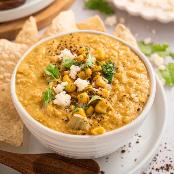 Creamy Mexican street corn chowder topped with corn, cotija cheese, cilantro, and black pepper.