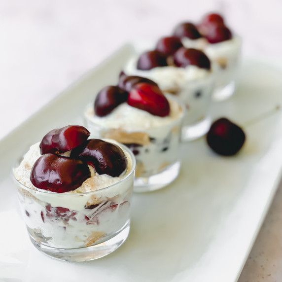Mini pots of cherry tiramisu aligned on white tray