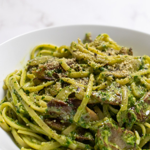 Mushroom pesto pasta shot from the side in a white bowl