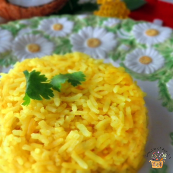 Nasi Kuning Rice with coconut milk and cilantro on a green and white plate with a red napkin