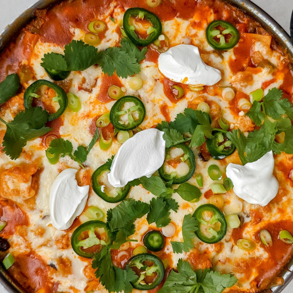 Skillet chicken enchiladas in a pan on white background