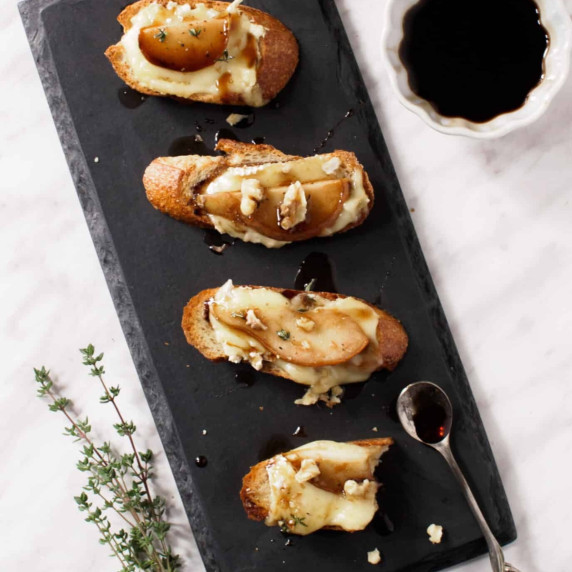 Pear and brie crostini on platter.