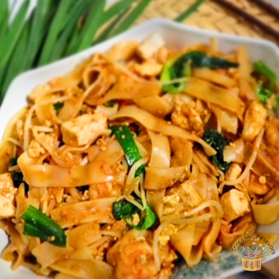 Char kway teow with wide rice noodles, shrimp, tofu, egg, and bok choy in a bowl