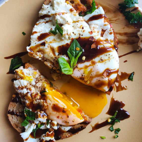 Golden yellow yolk, black balsamic reduction, green herbs, and a perfectly cooked egg.