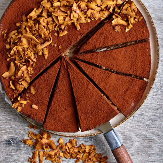Protein Chocolate Mousse Pie, dusted with cocoa and garnished with caramelised coconut chips.