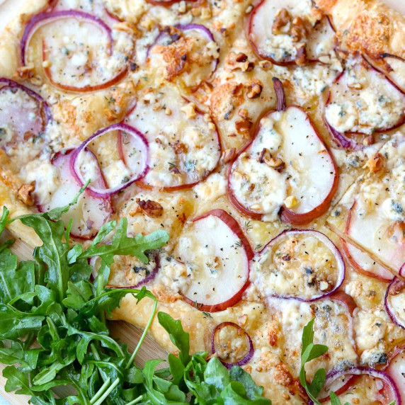 Puff pastry with arugula salad on cutting board