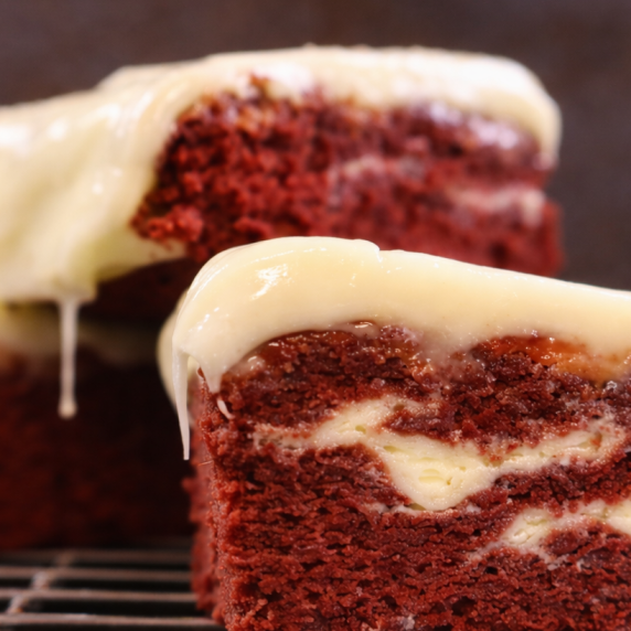 Red velvet brownies with cream cheese layers and glaze.