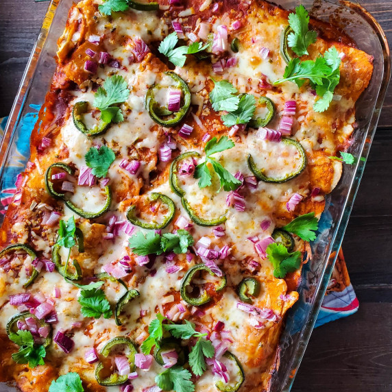 Bubbly enchiladas topped with melty cheese, red onion, jalapenos, and fresh cilantro.