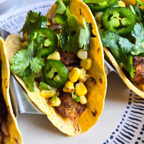 Yellow corn tortilla topped with golden potatoes, yellow corn salsa, and green cilantro & jalapenos