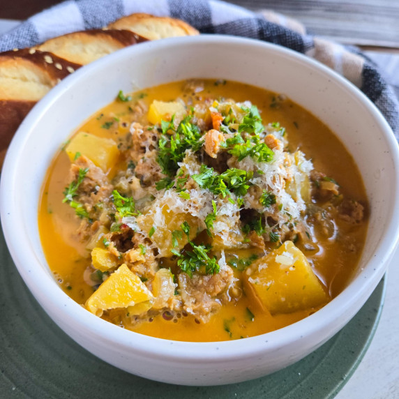 A big cozy bowl of creamy soup with pops of green parsley to finish.
