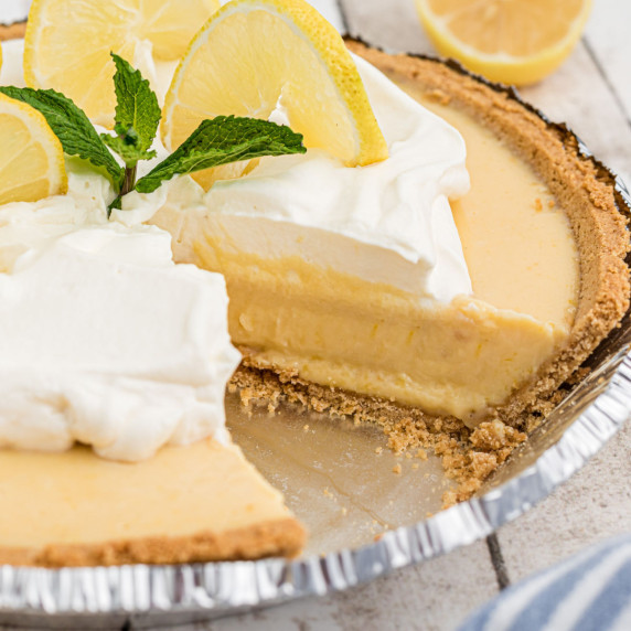 A shot of the side of a lemon pie with a slice taken from it.