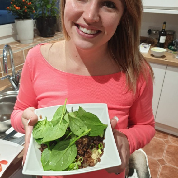 Girl holding Spaghetti Bolognese on a plate 