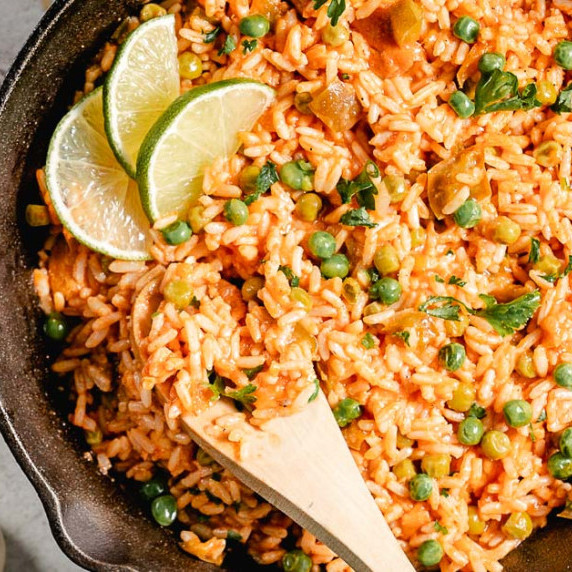 spanish rice in pan with wooden spoon