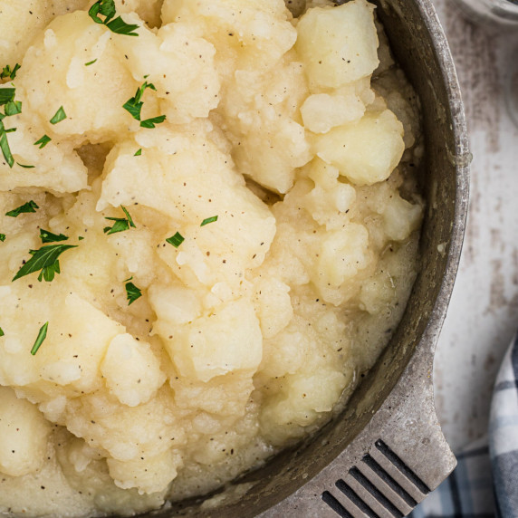 Close up shot of a pot of stewed potatoes.