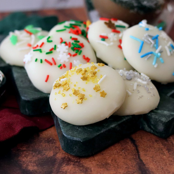 Sugar cookies piled on a Christmas tree serving board.