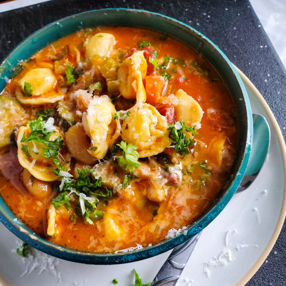A gorgeous, blue bowl, full of tomatoey, tortellini soup. 