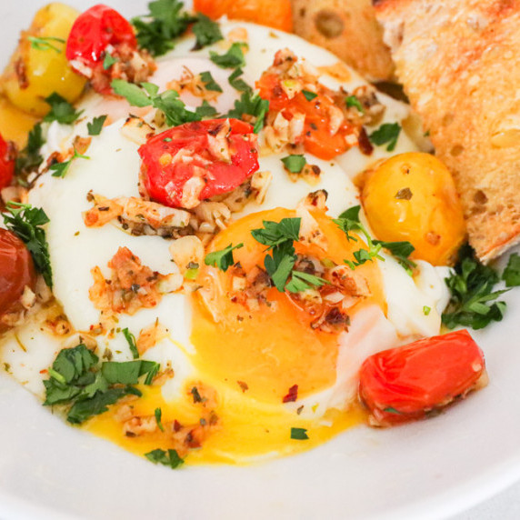 çilbir Turkish eggs with sautéed tomatoes and garlic aleppo oil