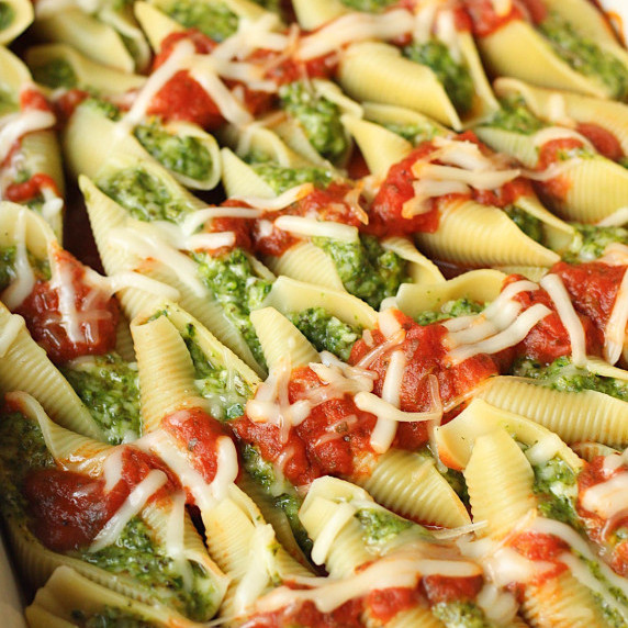vegan stuffed shells topped with sauce and vegan cheese
