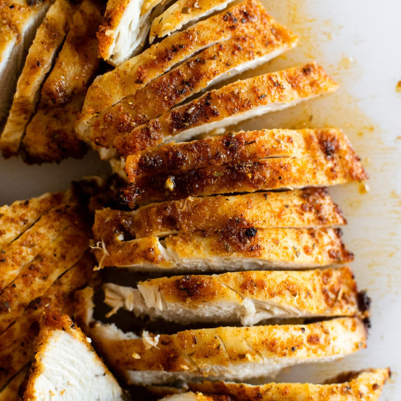 sliced chicken breast on a white cutting board.