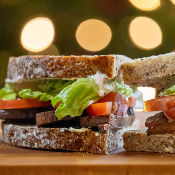 Vegan bacon in BLT sandwich with mayo dripping