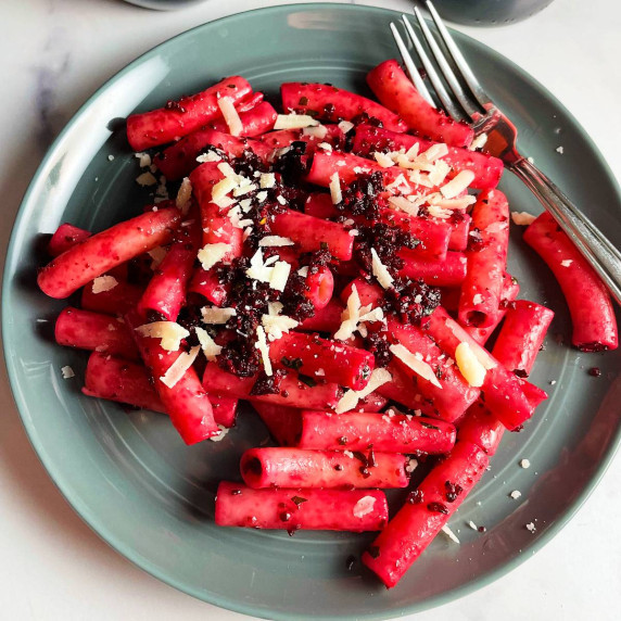 ziti with roasted beet pesto, on a gray plate.