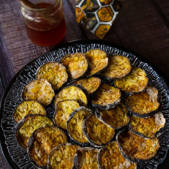 a plate of berenjena con miel sits drizzled with honey