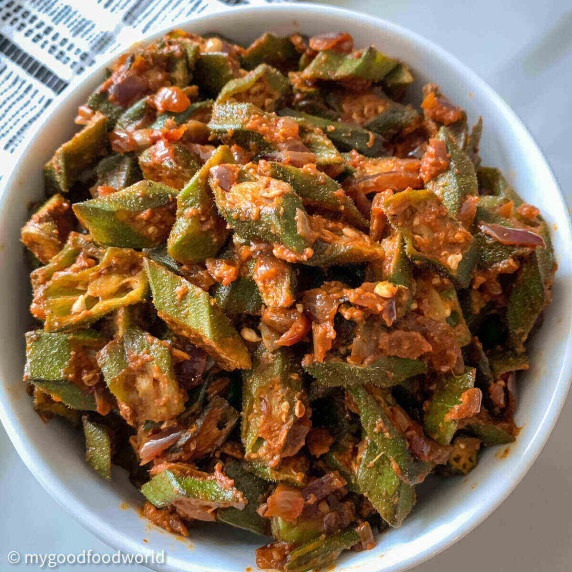 Okra vegetables cooked in spicy tomato gravy, and served in a round white bowl. 