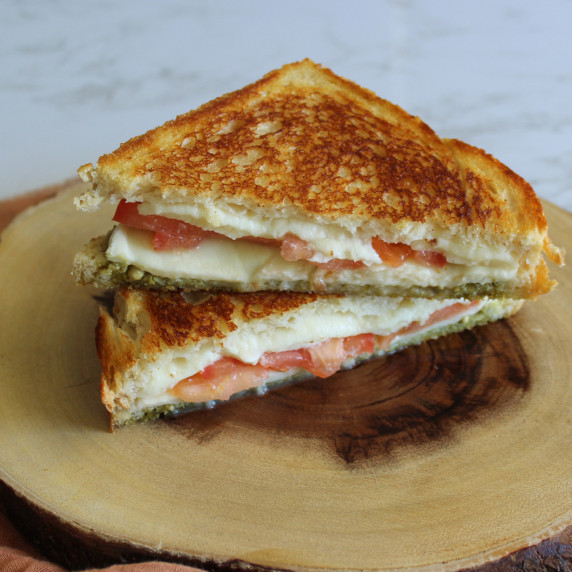 A crispy caprese pesto panini made with fresh mozzarella and tomato