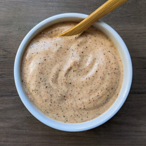 A small serving bowl of chipotle mayo with a wooden spoon