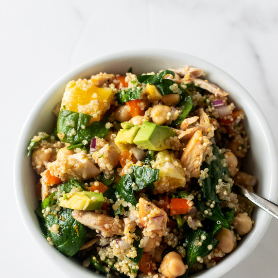 quinoa salad in a white bowl with fork on table