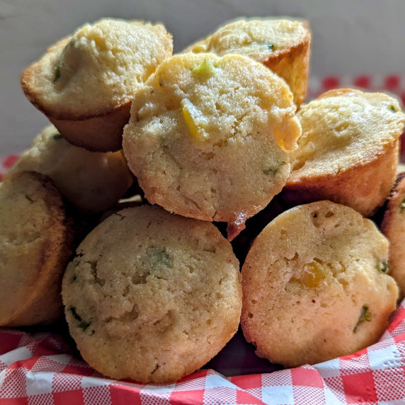 A pile of cornbread bites on a checkered napkin
