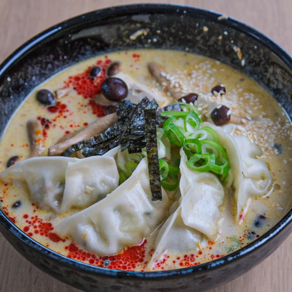 creamy ramen with gyoza dumplings in a bowl