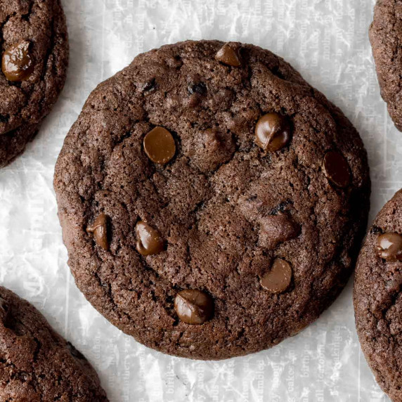 Dark chocolate blueberry cookies on white wax paper.