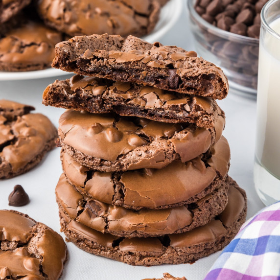 A stack of flourless chocolate brownie cookies with the top cookie broke in half.