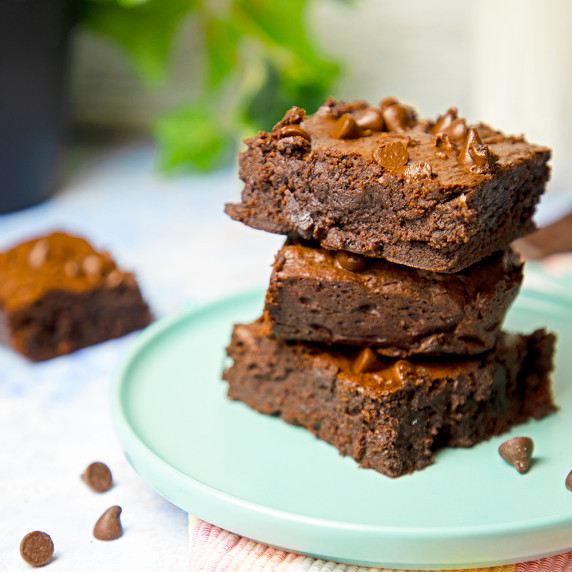 three fudge brownies stacked on top of each other. 