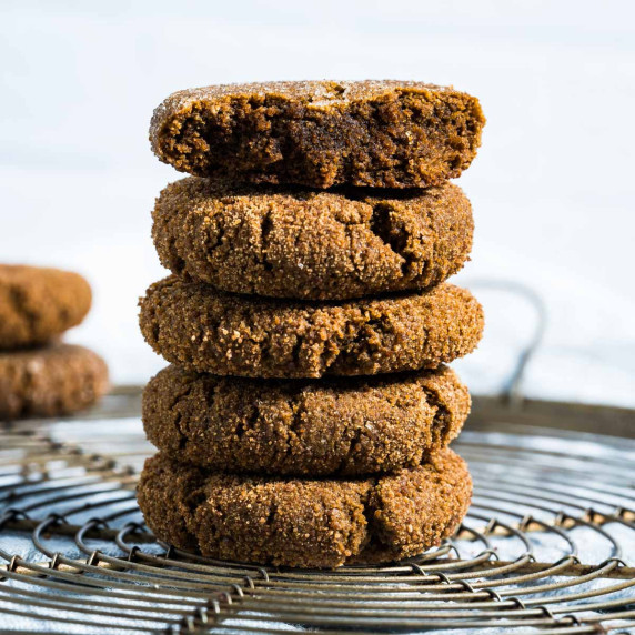 five cookies stacked with a bite out of top cookie, on a round cooling rack.