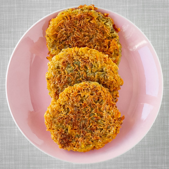 3 crispy potato pancakes on a pastel pink plate
