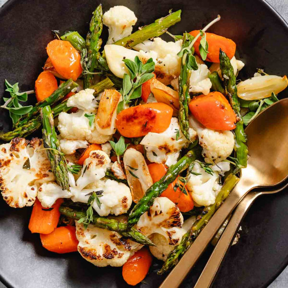 reoasted vegetables on a black plate.