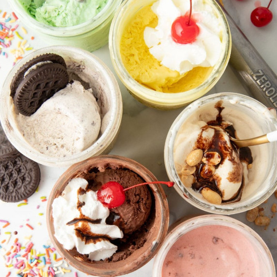 Overhead of six mason jars filled with different flavors of no-churn ice cream made right in the jar