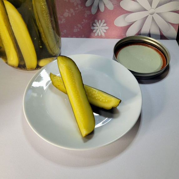 Two homemade pickles on a plate.