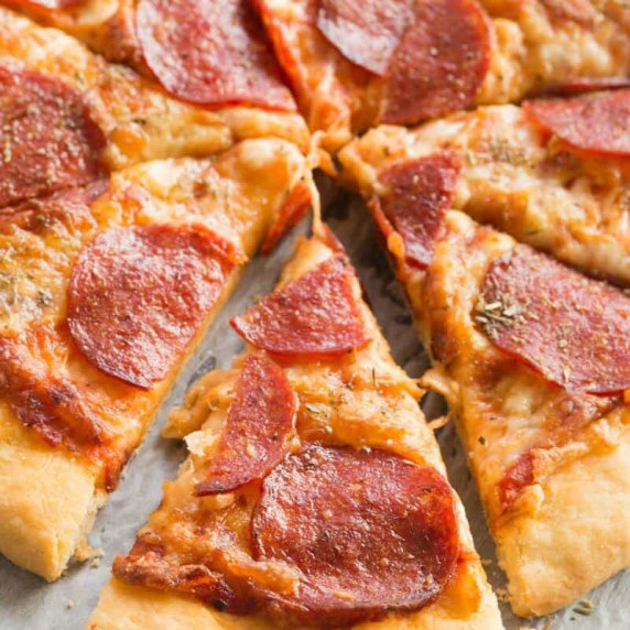 Closeup picture of keto pizza dough slices arranged together over a plate. 